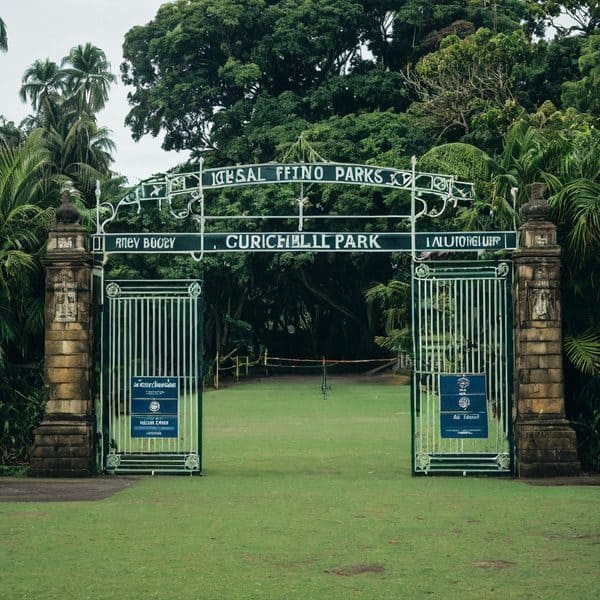 Entrance gate to Fiji's Laucala Bay Parks with lush greenery background.