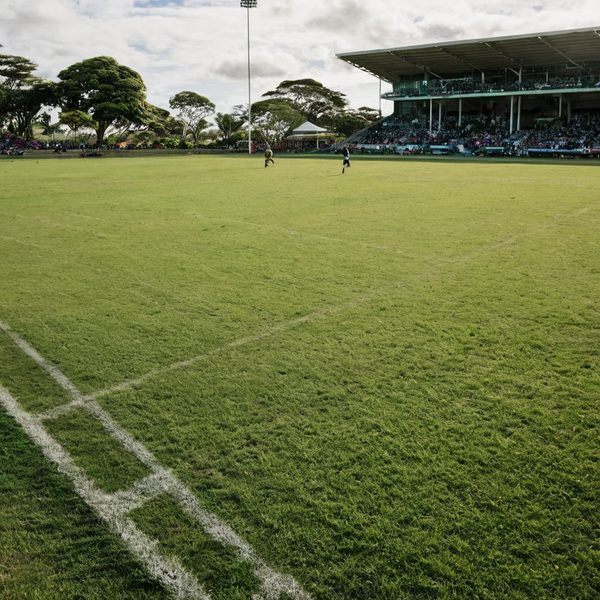 Cricket players on the field during a match at a local stadium in Fiji.