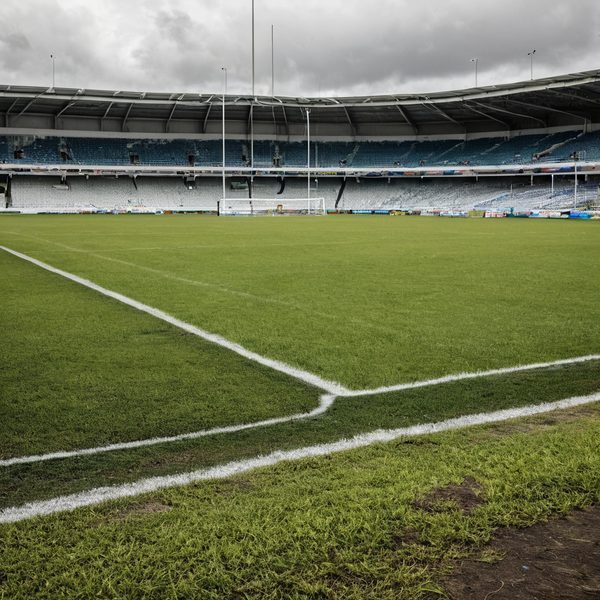 Rugby field at Fiji stadium with empty stands and cloudy sky.