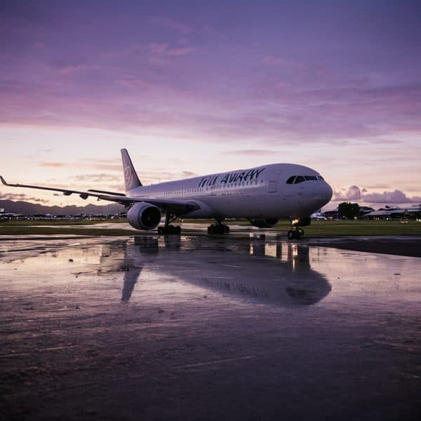 Fiji Airways aircraft on the runway during sunset with vibrant sky colors.