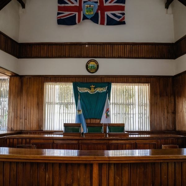 Interior of Fiji government meeting room with flags and wooden decor.