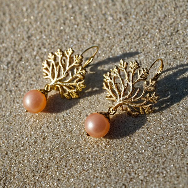 Elegant gold coral-shaped earrings with pink pearls, perfect for summer beachwear.