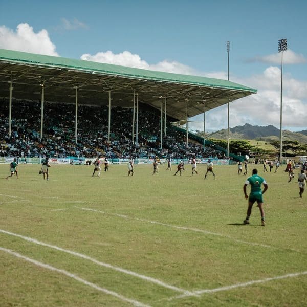 Fiji rugby players competing in a match at a local stadium with spectators.