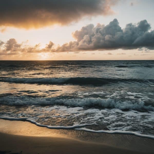 Sunset over the Fiji ocean with waves crashing on the shore.